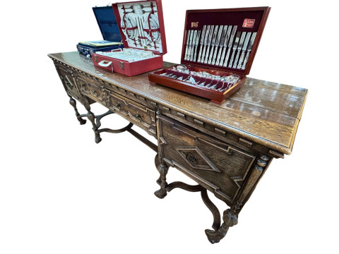 Jacobean style large oak sideboard having two frieze drawers flanked by two cupboards, raised on elaborate carved legs and understretchers by Druce & Co, Baker St, London, 228cm by 63.5cm by 96cm. thumbnail
