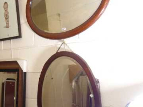 Two oval framed mirrors