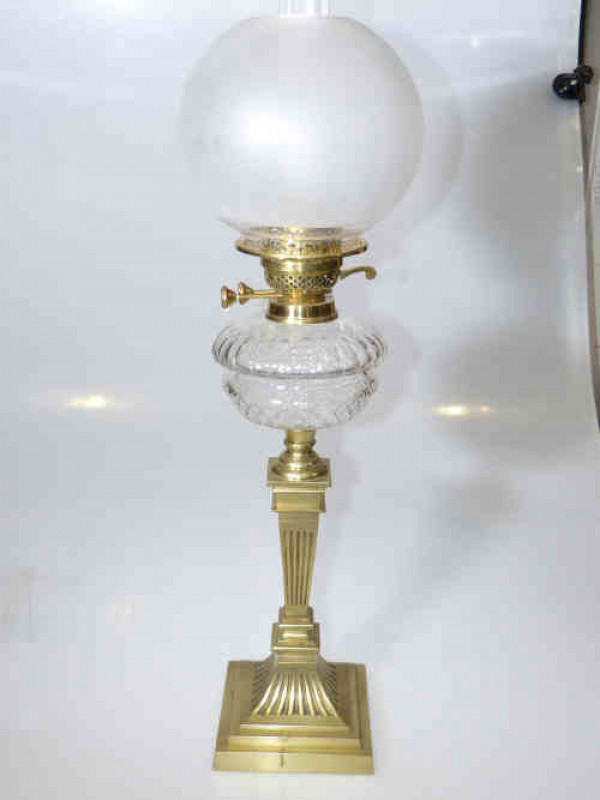 Brass column oil lamp with clear cut glass reservoir and frosted shade