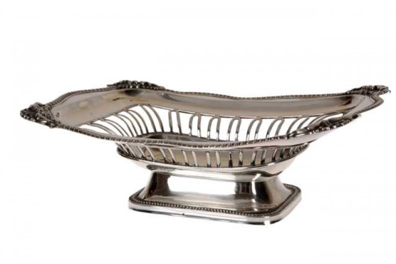 An Edwardian pierced silver basket, Walker & Hall, Sheffield 1907, of shaped rectangular form with gadrooned rim and shell cast corners, raised on a stepped foot. Approximately 16 troy ozs, 25cm by 18cm
