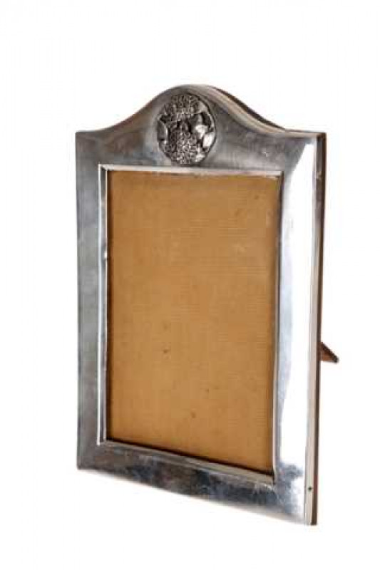 A George V silver photograph frame, Birmingham 1915, rectangular easel form with break arch top, with pierced Art Nouveau roundel in the arch. 19.5cm by 13.5cm
