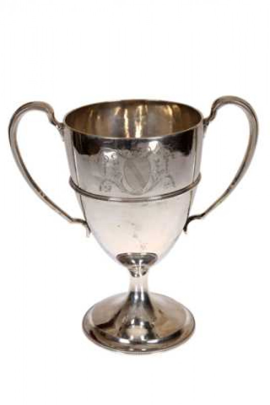 A George III Irish silver trophy, Dublin 1763, with beaded band and twin handles, engraved with a crest and raised on a beaded circular foot. Approximately 27.9 troy ozs, 23cm