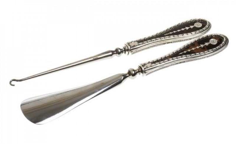 Silver and tortoiseshell shoehorn and boot pull, William Comyns, London 1913 and 1914, each handle cast with bellflowers. (2) Boot pull 26cm
