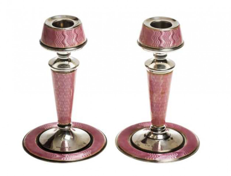 A pair of silver and pink enamel candlesticks, London 1930, maker's mark indistinct, each with engine turned decoration, marks polished to one, weighted. 14cm