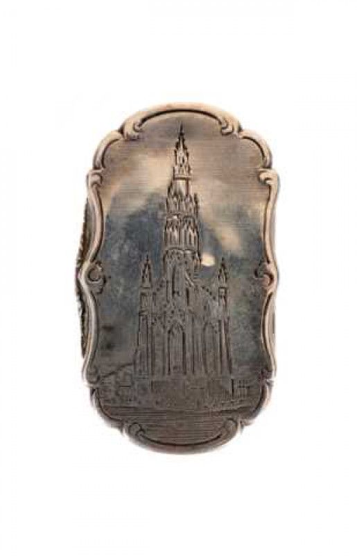 A Victorian silver vinaigrette, Nathaniel Mills, London 1848, of shaped rectangular form, engraved with a Cathedral, lacking grille. 48mm by 28mm