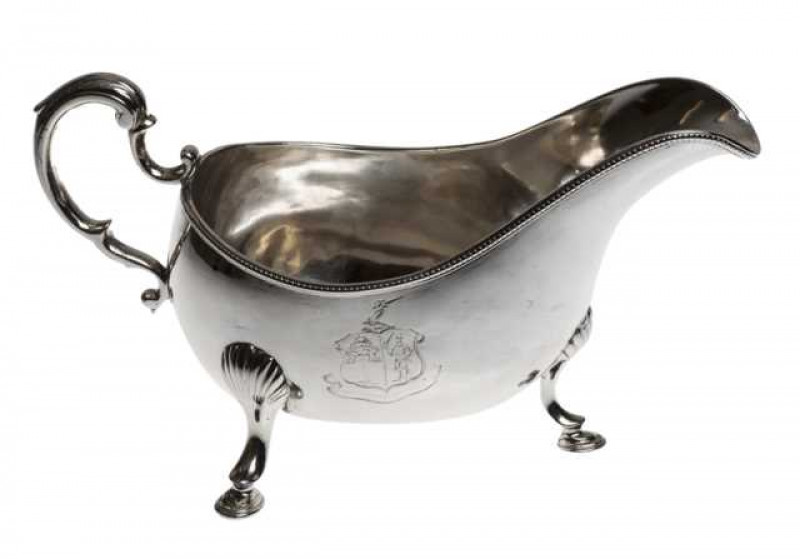 A George III Irish silver sauce boat, probably Bartholomew W. Delandre, Dublin 1776, date letter polished, with beaded rim and shell capped legs, engraved with a coat of arms. Approximately 11.9 troy ozs, 22cm