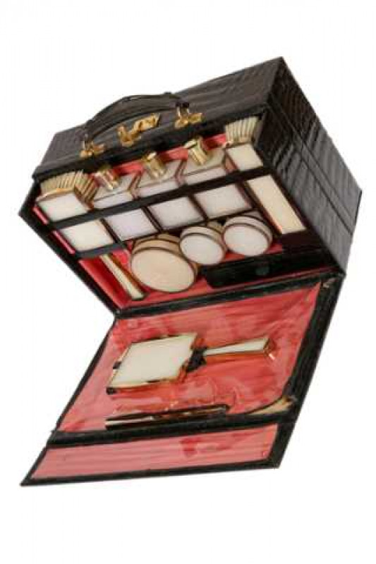 Asprey: A silver gilt mounted vanity or dressing set, London 1961, the crocodile leather case containing moulded plastic bottles, brushes, jars, mirror and comb, quatrefoil hallmark and stamped ASPREY LONDON, the case applied with the initials MCC. Case 2