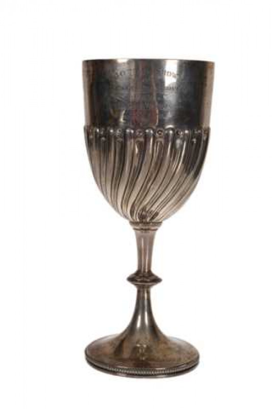 An Edwardian silver cup, Charles Stuart Harris, London 1902, the cup with reeded and fluted swirls, raised on a drawn stem with beaded knop, a beaded circular foot below, engraved BOTHAL SHOW 1902... Approximately 12 troy ozs, 25.5cm