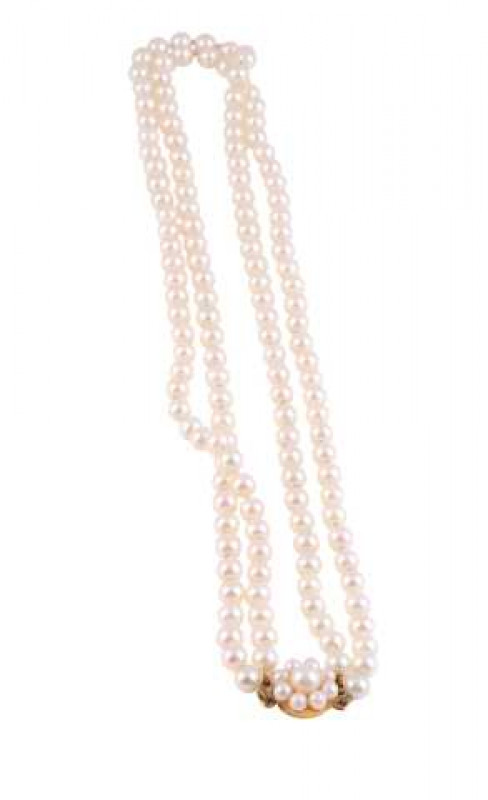 A cultured pearl necklace, the graduating double row of graduating cultured pearls strung simply onto an oval integral tongue clasp with delicate pierced and beaded detailing. 180 pearls in total. Clasp stamped 375 (very worn). Weight approx. 27.7gms. Len