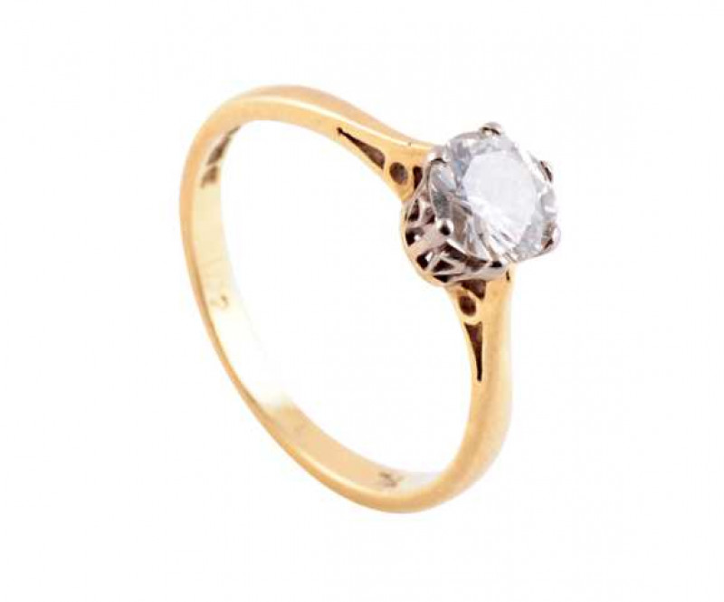 A single stone diamond ring, the brilliant cut diamond six claw set in a pierced detail mount between tapering pierced detail shoulders on a plain band. Stamped 750. Ring size K.
