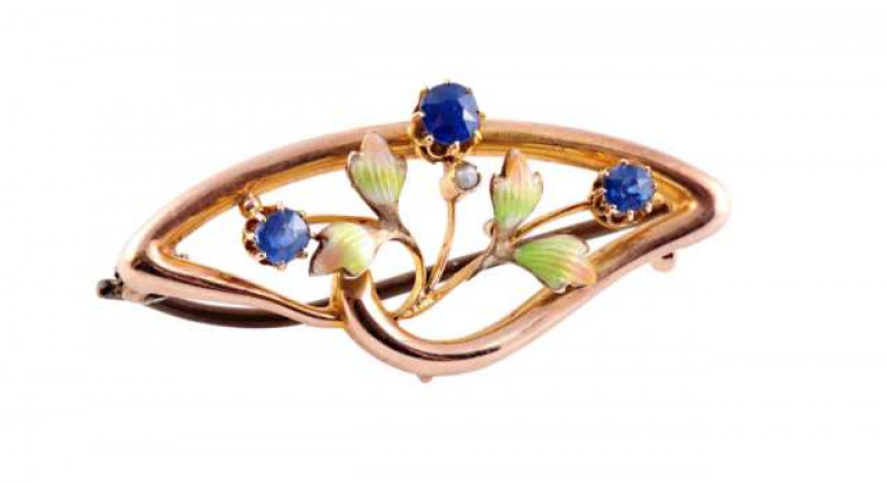 An Art Nouveau enamel and sapphire brooch, the three graduating round cut sapphires each eight claw set evenly spaced to the inner edge, each set to the top of three knife edge bars set with four leaf shaped mounts in delicate green guilloche enamel and a