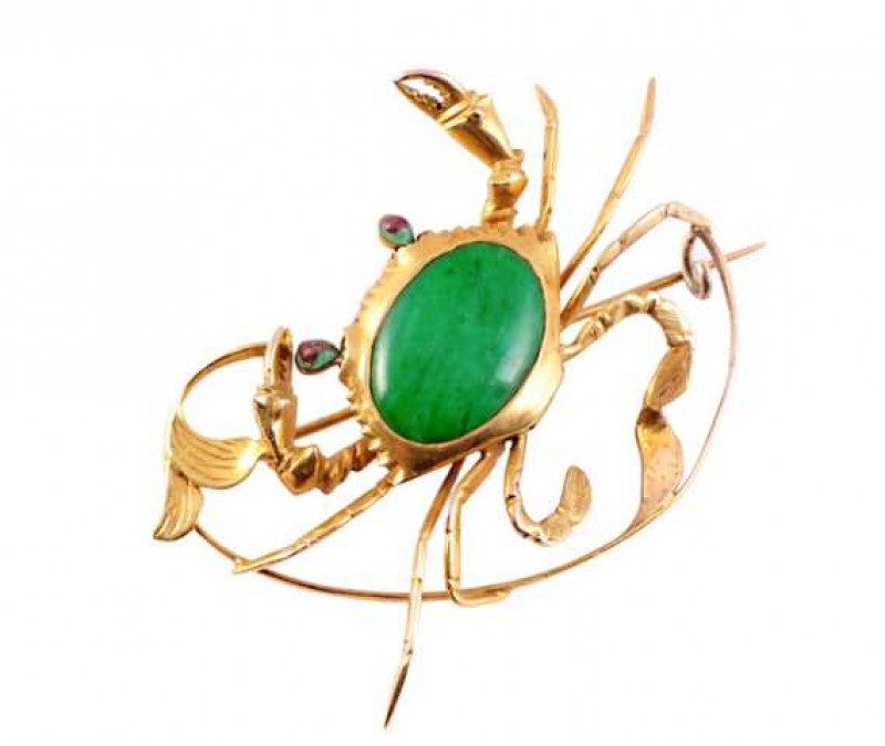 A jadeite brooch, modelled as a crab, the realistic moulded design set to the centre with an oval cut collet set jadeite plaque as the body, within moulded bars depicting the pincers and legs and two jadeite highlights for the eyes. Brooch pin fitting. We