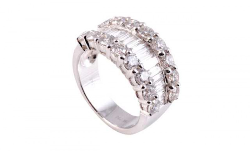 A diamond ring, the thirteen channel set baguette cut diamonds set to the centre of the mount between two rows of eight brilliant cut claw set diamonds to either side, all set in open mounts on a wide plain band. Stamped 18K 750. Ring size M1/2