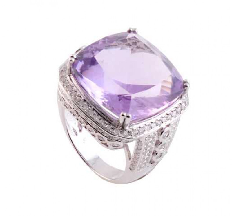 An amethyst and diamond ring, the large cushion cut amethyst four double claw set in a mount set throughout with brilliant cut diamond highlights to the top and sides, the elaborate and heavily pierced mount set with a further eight graduating collet set 