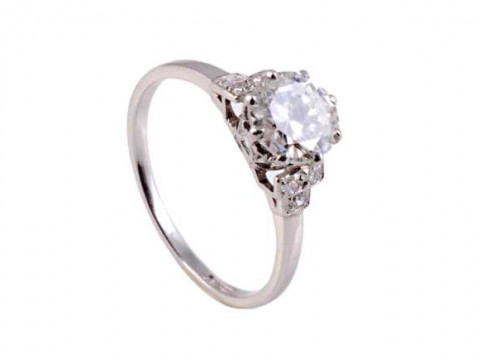 A diamond ring, the central brilliant cut diamond eight claw set in a...