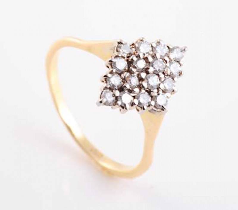 A diamond ring, the marquise shaped mount set to the centre with four brilliant cut claw set diamonds, slightly raised within a bezel of twelve brilliant cut claw set diamonds, all set in a pierced mount between tapering shoulders on a plain band. Stamped