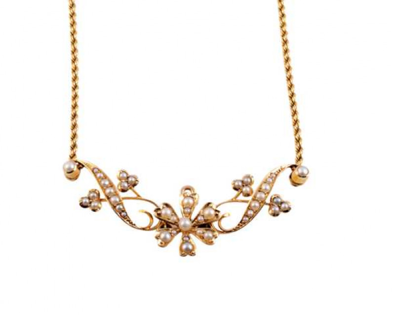 An Art Nouveau seed pearl and gold pendant, the central flowerhead mount set to the centre with a single seed pearl, six petal shaped mounts spaced evenly to the outer edge each set with two graduating seed pearls, to the top a retractable pendant loop, s