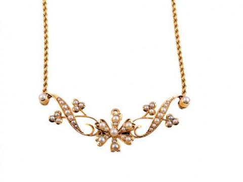 An Art Nouveau seed pearl and gold pendant, the central flowerhead mount...