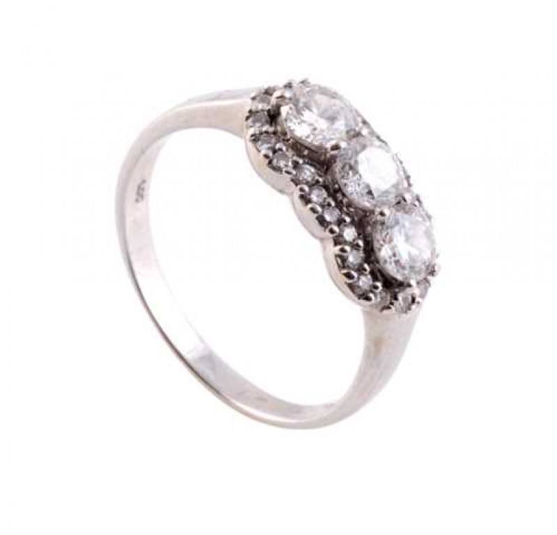 A diamond ring, the three uniform brilliant cut claw set diamonds raised within a surround of twenty four brilliant cut claw set diamond highlights, all set in an open mount between plain shoulders on a plain band. Ring size P.