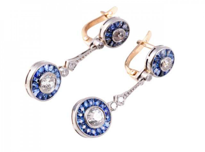 A pair of sapphire and diamond drop earrings, the brilliant cut collet set diamond set within a bezel of fifteen square cut sapphires in a collet mount, suspending from an articulated brilliant cut diamond set collet link, in turn suspending from a shaped