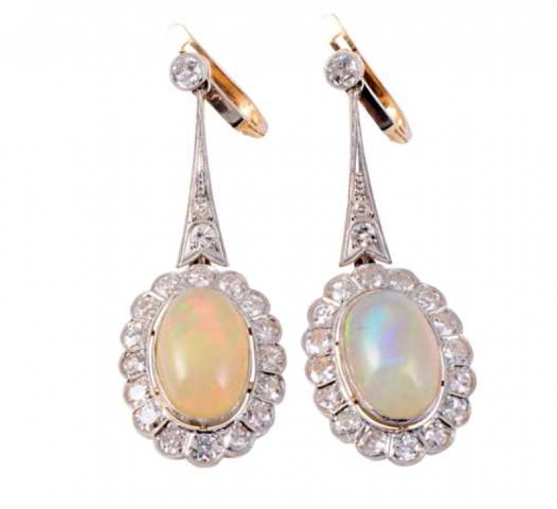A pair of opal and diamond drop earrings, the oval cut opal collet set within a bezel of sixteen round mixed cut diamonds claw set in shaped mounts, suspending on an articulated link from a shaped bar set with two round mixed cut diamond highlights to the