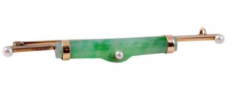 A jadeite and seed pearl bar brooch, the cylindrical jadeite set to the centre of a flat edge bar with a single seed pearl highlight to the centre and two moulded band terminals to each end, all set between two seed pearl highlight terminals to each bar e