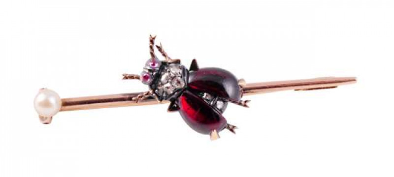 A garnet, diamond and seed pearl brooch, circa 1870, modelled as a fly to the centre of the cylindrical brooch bar, the realistic design set with two cabochon cut garnets as the wings to either side of two old cut diamond highlights set to the body, four 