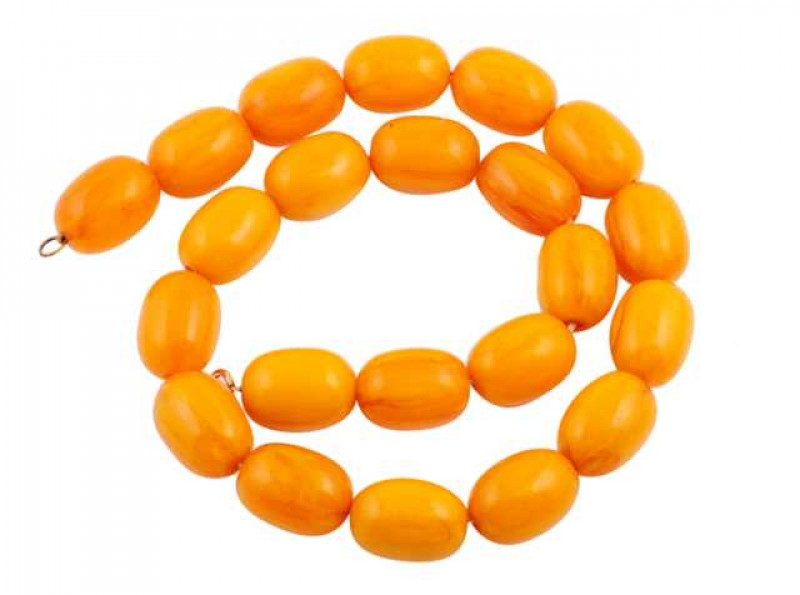 A single strand of twenty two uniform oval shaped amber beads, strung simply onto a bolt ring clasp. Weight approx. 151.1gms. Length approx. 59cm. NB These beads have not been tested for enhancement.