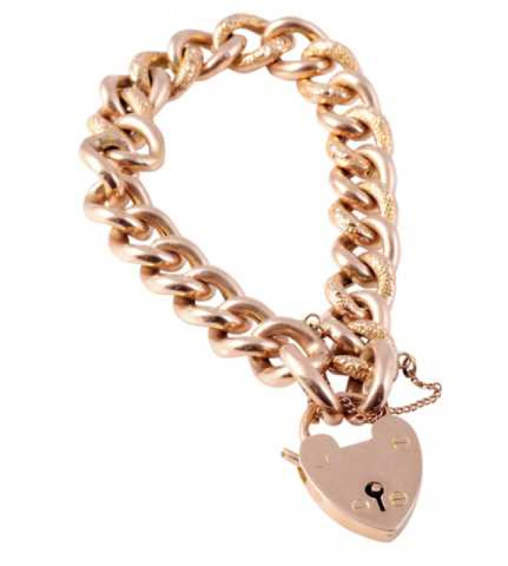 A late 19th Century yellow gold curb link bracelet, the twenty five large curb links, alternately textured gold and plain gold, held with a clasp designed as a heart padlock and safety chain. Reverse stamped 9 carat. Weight approx. 20.7gms.