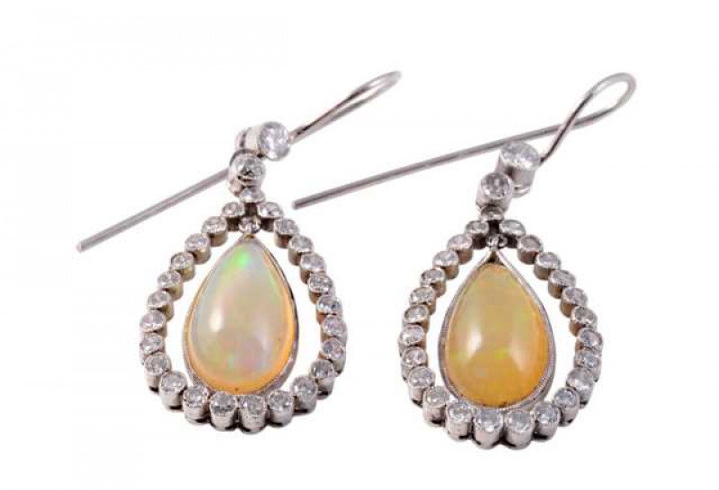 A pair of opal and diamond drop earrings, the oval cut opal collet set on an articulated link to the centre of an open mount set with twenty five old brilliant cut diamonds in separate collet settings, all suspending on an articulated link from a single o
