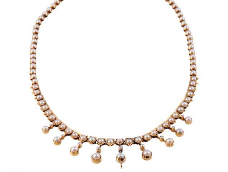 A seed pearl necklace, circa 1890-1900, set to the entirety with eighty one slightly graduating seed pearls, forty nine seed pearls set in articulated collet settings, thirty two seed pearls set to the bottom claw set in shaped mounts, suspending nine kni