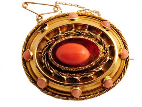 A mid Victorian coral brooch, set to the centre with an oval shaped coral...