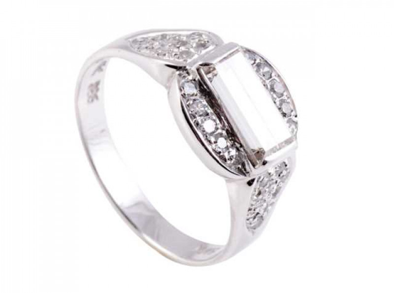 A diamond ring, the oval shaped mount set to the centre with a horizontal set baguette cut collet set diamond, within a surround of ten brilliant cut diamond highlights, set in an open mount between shaped tapering shoulders each set with ten brilliant cu