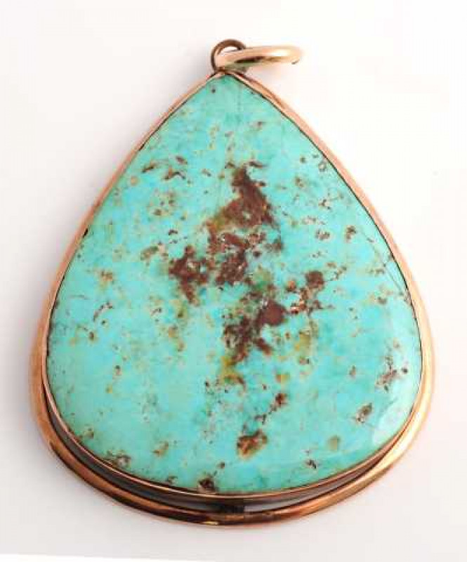 A turquoise pendant, the tapering oval cut turquoise set simply in a collet set mount suspending from a simple bolt ring. Weight approx. 26.2gms. Length approx. 5.5cm.