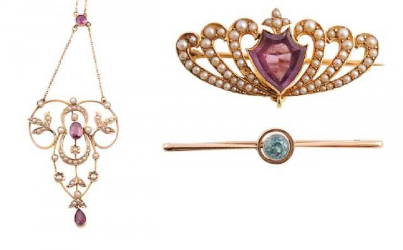 An Edwardian amethyst and seed pearl necklace, set to the centre with an oval cut collet set amethyst within a delicate open work mount set throughout with graduating seed pearl highlights in collet sets or leaf or flower head shaped settings, suspending 