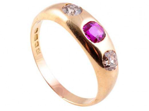 A diamond and ruby ring, the round mixed cut ruby collet set between a...