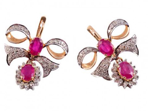 A pair of ruby and diamond earrings, the oval cut ruby four claw set within...