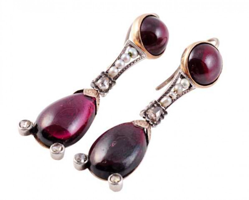 A pair of garnet, seed pearl and diamond earrings, circa 1800, the oval cabochon cut garnet set to the bottom with two collet set old cut diamond highlights, suspending on an articulated link from a curved rectangular link set to the bottom with an old cu