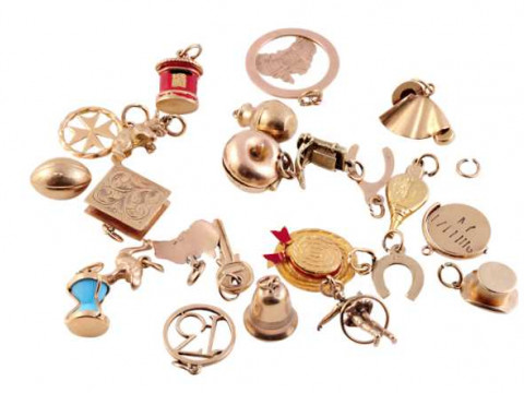A collection of twenty three charms, to include a bell, two hats, a book,...