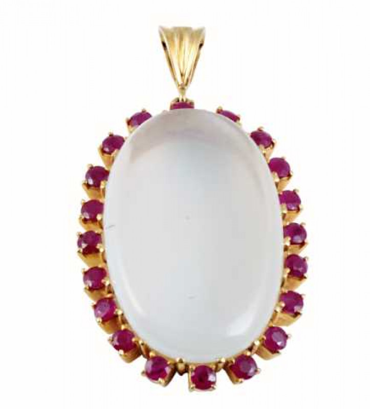 A moonstone and ruby pendant, the large oval cut moonstone claw set within a surround of twenty evenly spaced round cut claw set rubies, all set in open mounts suspending from a moulded oval shaped bale. Length approx. 4.5cm. Weight approx. 14.3gms.