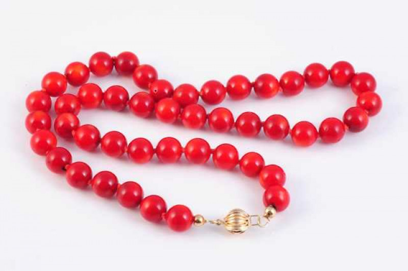 A red coral necklace, the forty six uniform coral beads threaded onto a moulded barrel clasp. Weight approx. 47gms. Length approx. 23cm.