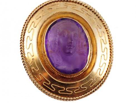 A Victorian cameo brooch, the oval cut amethyst carved to depict a bust...