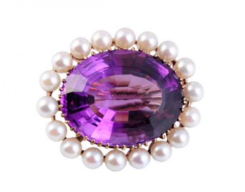 An amethyst and cultured pearl brooch, the large oval cut amethyst claw set in an open mount within a surround of eighteen cultured pearls. Brooch pin fitting. Stamped 9ct. Weight approx. 12.3gms. Length approx. 3cm. Width approx. 2.7cm.