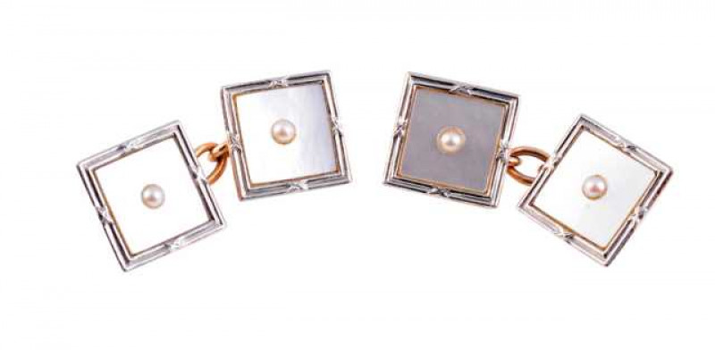 A pair of seed pearl, mother of pearl and platinum cufflinks, circa 1900, the square shaped plaques of mother of pearl set to the centre with a single cultured pearl highlight, within a subtle moulded detail border, joined by a simple oval link chain. Mak