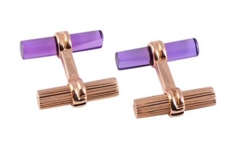 Boucheron: A pair of yellow gold cufflinks, the fixed and moulded bar design set to one end with a cylindrical textured gold bar, the other end set with a tapering purple coloured cylindrical bar. Makers mark BOUCHERON. Stamped 750. Weigh of one cufflink 