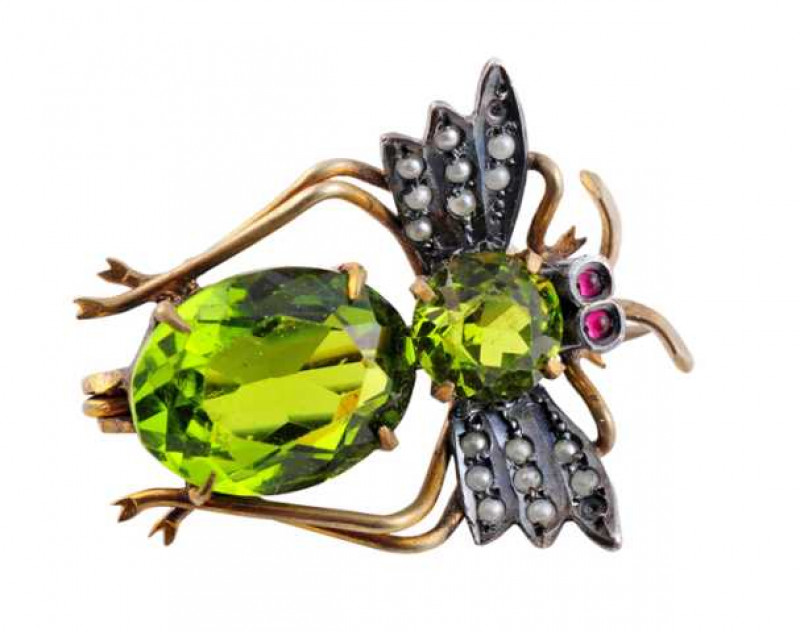 A late Victorian brooch, modelled as a fly, the large oval cut glass four claw set to the bottom of a smaller round cut four claw set glass, in turn between three strand designed wings, each set with eight seed pearl highlights (2 lac