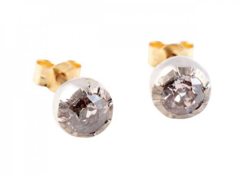 A pair of diamond stud earrings, the round mixed cut diamond set in a heavy collet setting on post and scroll fittings. Weight of one earring approx. 1gms.