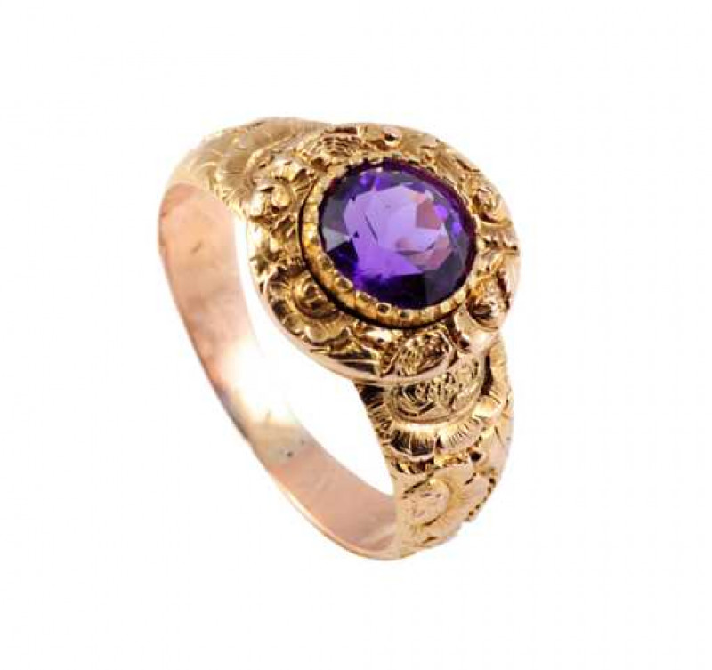 A 19th Century amethyst ring, the round mixed cut amethyst collet set in a heavily moulded mount to the top of a similarly heavily moulded and chased detailed band. Ring size M1/2