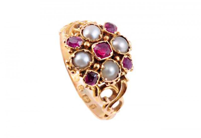A ruby and seed pearl ring, circa 1870, the square cut ruby collet set to the centre of four smaller square mixed cut collet set rubies, alternately spaced with four collet set seed pearls, all set on a moulded mount set throughout with beaded detailing b