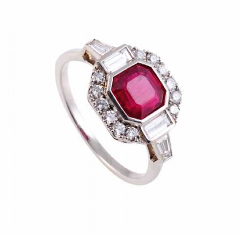 A ruby and diamond ring, the step cut ruby collet set within a bezel of twelve brilliant cut claw set diamonds and two collet set baguette set diamonds, all set in an open mount between open shoulders each set with a collet set tapering baguette cut diamo